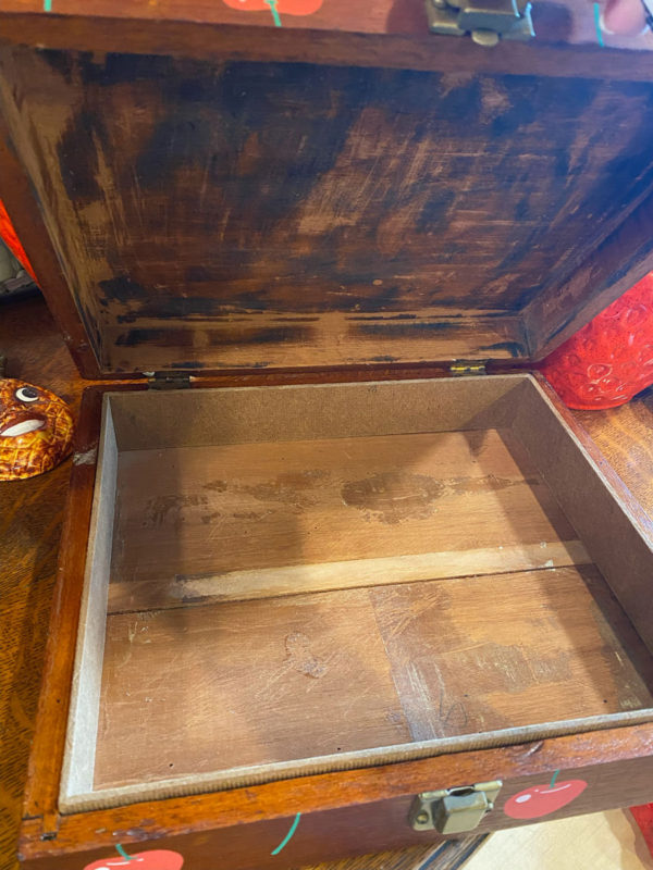 Photo showing the interior of a wooden box with a hinged lid, opened